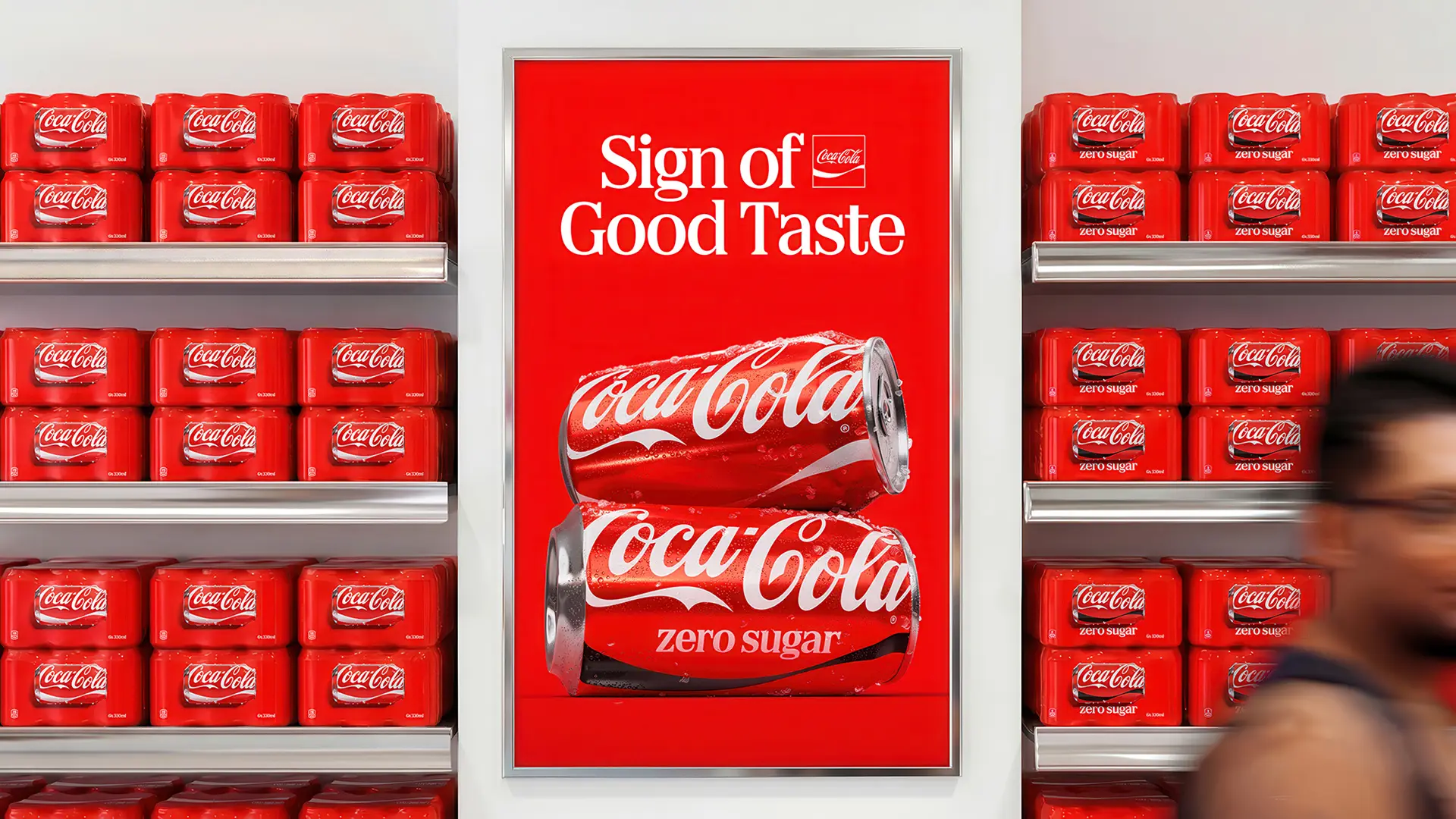 Coca‑Cola red unified-shelf display with 'Sign of Good Taste' poster (Zero Sugar cans)