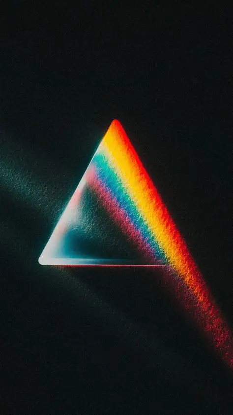 Glass prism refracting rainbow spectrum on black background