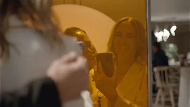 Unmistakably West Hollywood — Amber-tinted mirror selfie in a warm indoor setting