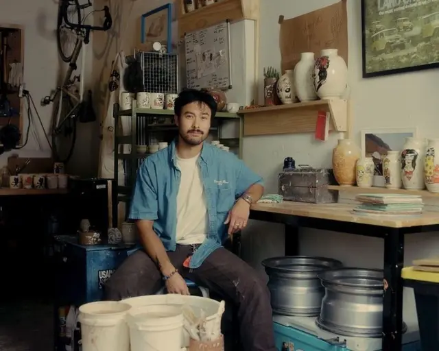 Workshop portrait in a ceramics studio with vases and metal rims