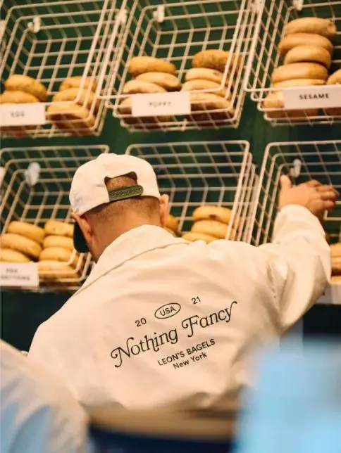 Nothing Fancy jacket in front of wall of bagels