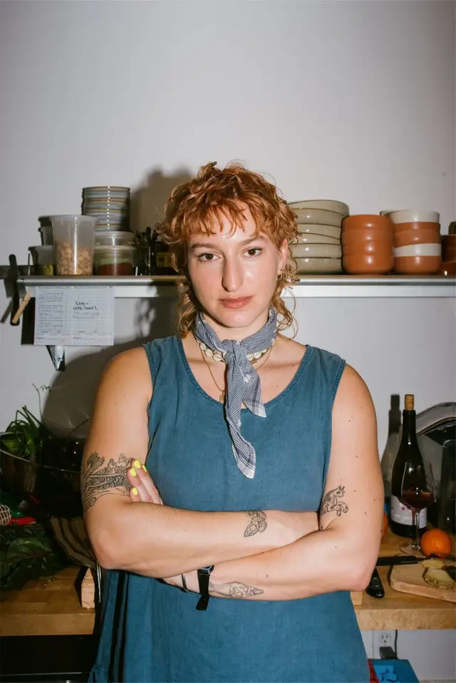 Kitchen portrait — woman in blue sleeveless dress with neckerchief and tattoos
