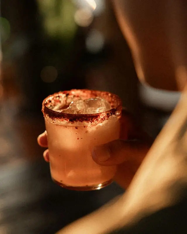Chili-salt rimmed cocktail in a rocks glass with crushed ice