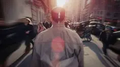 Backlit commuter walking through busy city street at golden hour