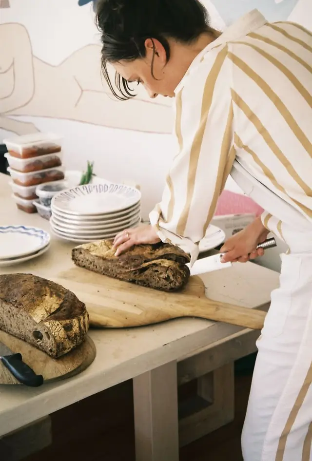 Artisan sourdough loaves sliced on wooden paddle in home kitchen