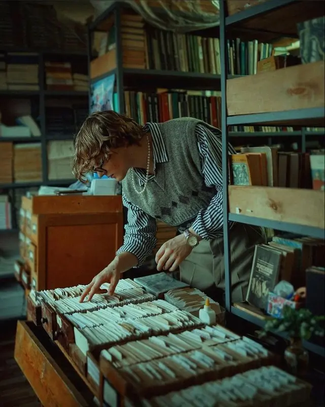 Browsing wooden crates of vintage record sleeves in a secondhand book-and-record shop