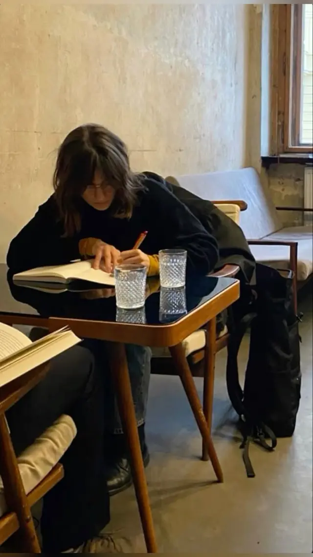 Journaling at a mid-century wooden café table