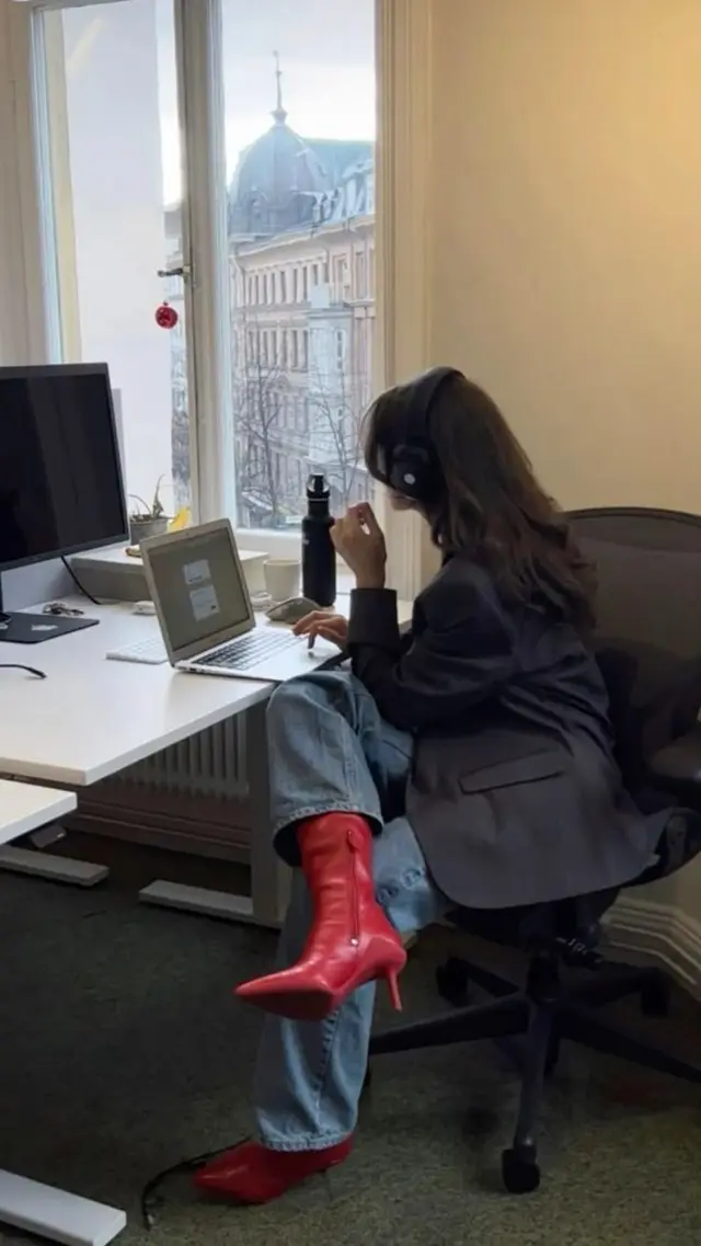 Office scene: red stiletto boots and laptop at window desk