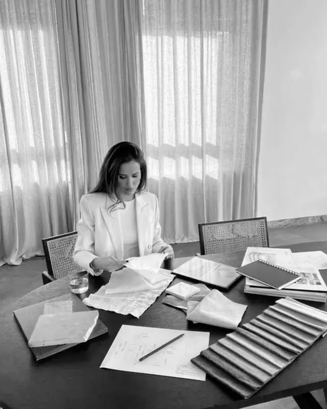 Woman Reviewing Fabric Swatches at a Sunlit Design Table (black-and-white)