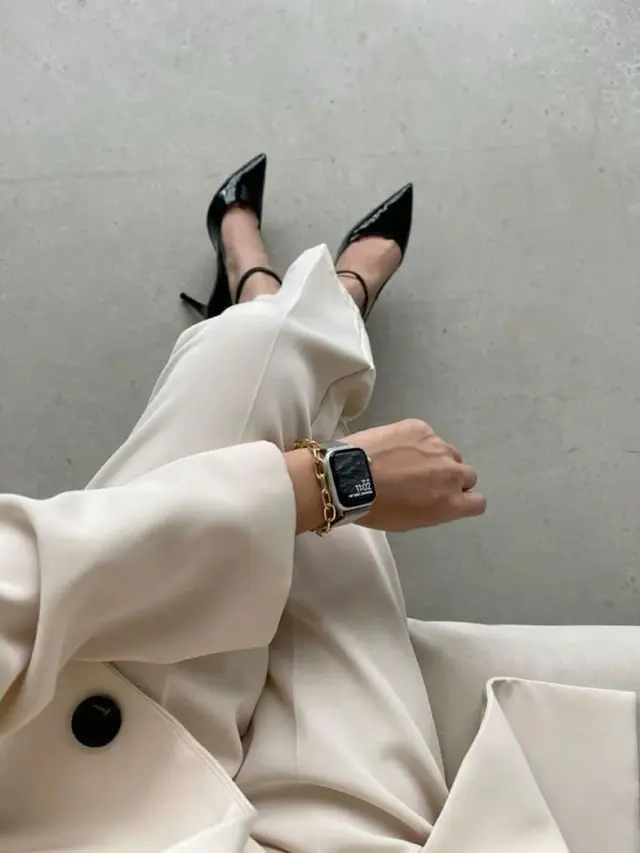 Cream tailored suit with black patent ankle-strap heels and smartwatch