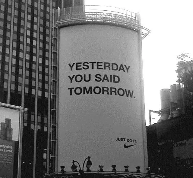 Nike billboard — "Yesterday You Said Tomorrow" large cylindrical outdoor ad (black-and‑whi