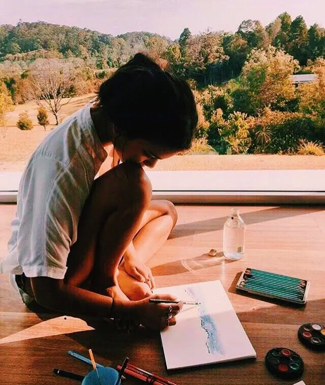 Watercolor painting by a floor-to-ceiling window with forest view