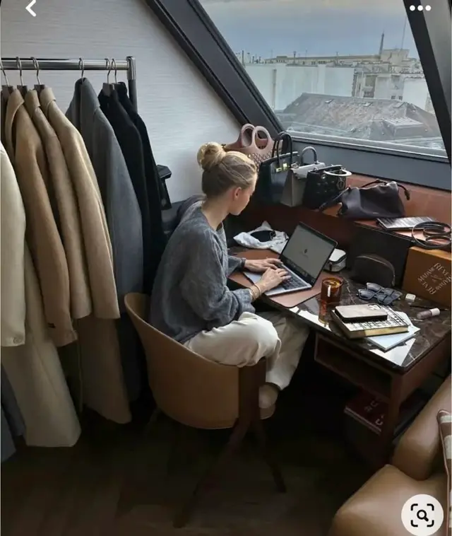 Cozy loft workspace with clothing rack and skylight