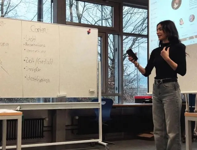 Classroom presentation beside mobile whiteboards with handwritten German notes