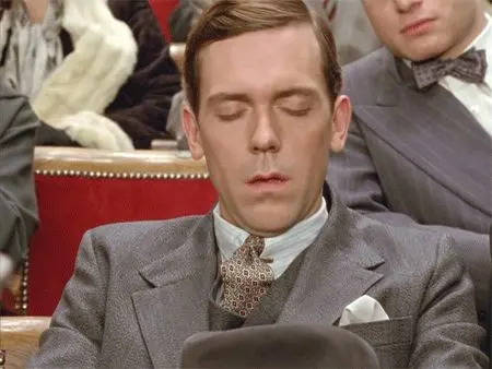 Man dozing in grey three-piece suit — vintage theater film still