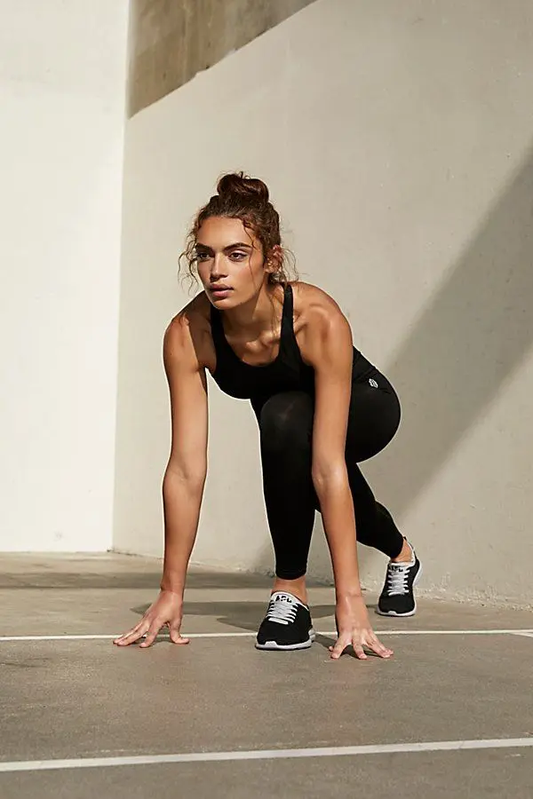 Runner in Starting Stance — Black Tank and Leggings on Concrete