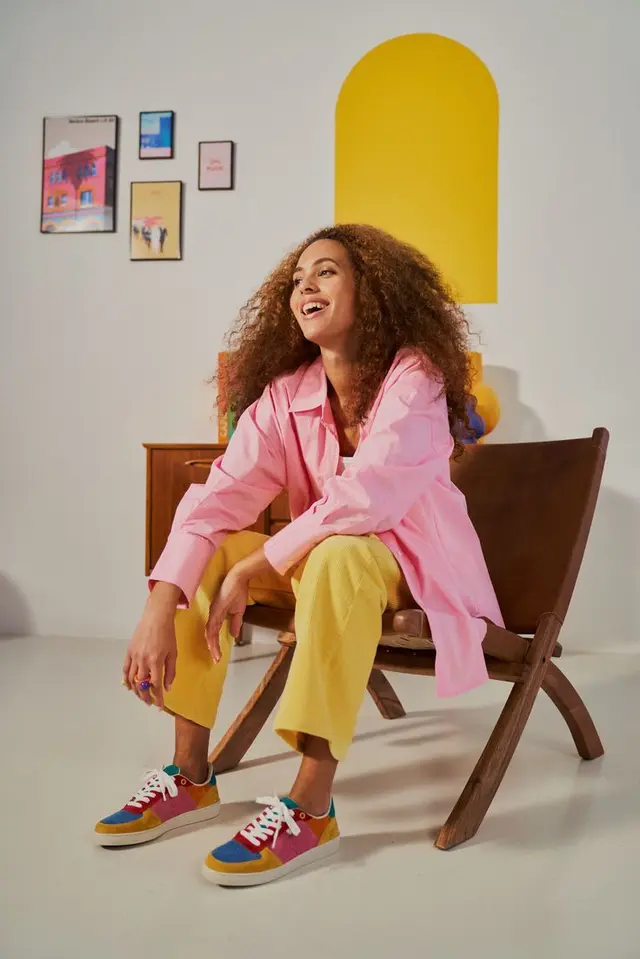 Color-blocked casual outfit: pink overshirt, yellow trousers, multicolor sneakers