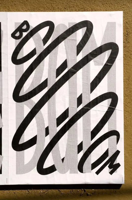 Black gestural spiral over halftone typographic poster on ochre stucco wall