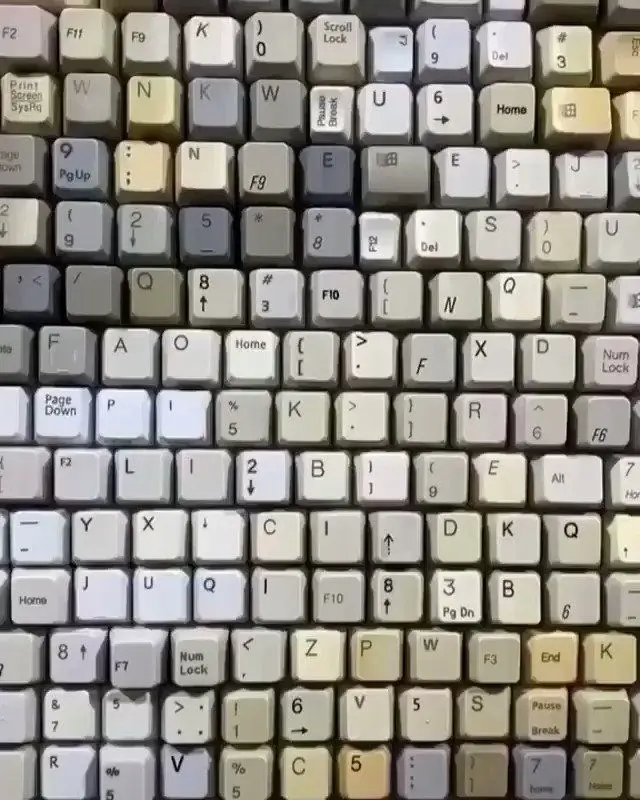 Mosaic of mixed vintage keyboard keycaps — beige & gray grid