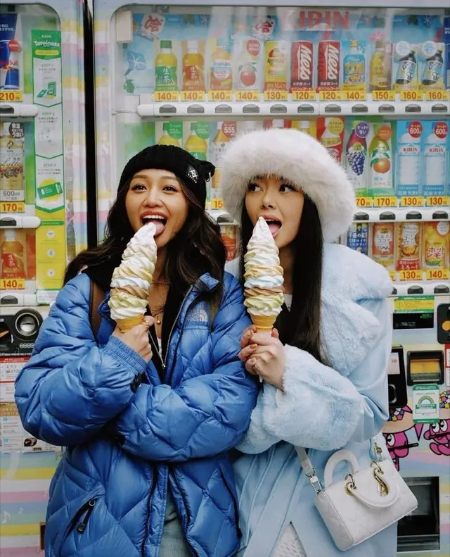 Friends with oversized pastel soft-serve in front of colorful beverage vending machine