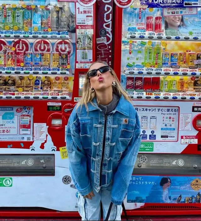 Street-style portrait in front of red Japanese vending machines