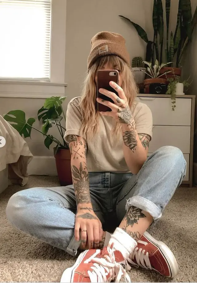 Casual mirror selfie with beanie, tattoos, rolled jeans and plants