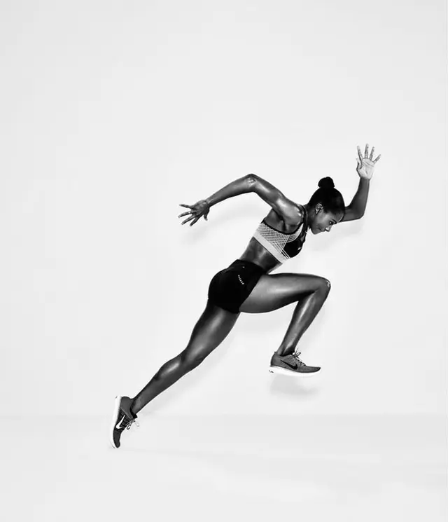 Black-and-White Studio Shot of Female Sprinter Mid-Jump
