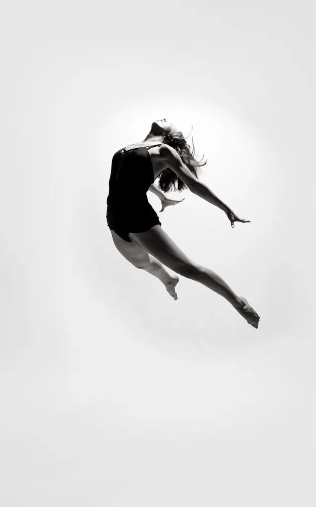 Black-and-White Studio Photo — Dancer Mid‑Air Back‑Arch Leap