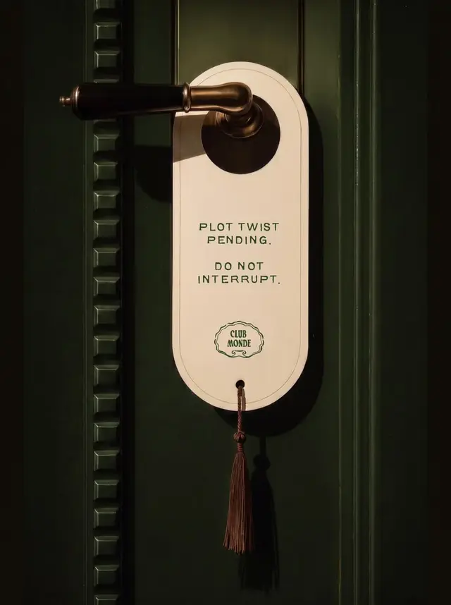 Cream door hanger reading "PLOT TWIST PENDING" on dark green paneled door