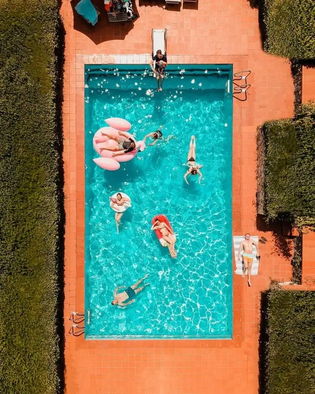Aerial view — turquoise pool on terracotta patio with pink flamingo float