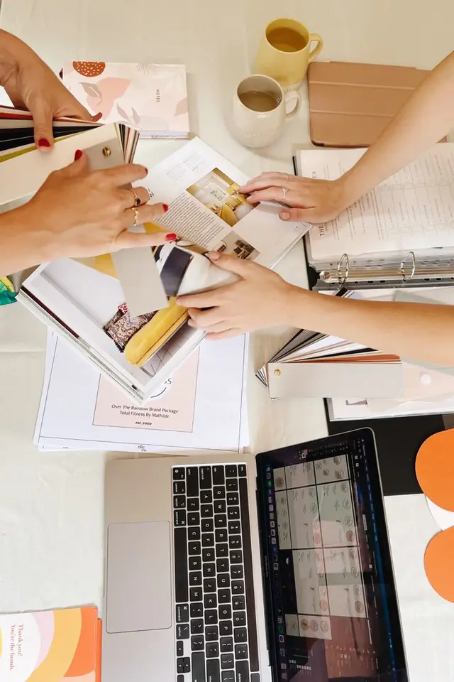 Branding review flat-lay with swatch books, mockups and laptop