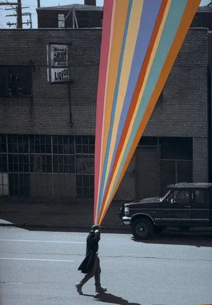 Falling with Lora Fosberg — Pedestrian with Multicolored Beam Outside Brick Storefront