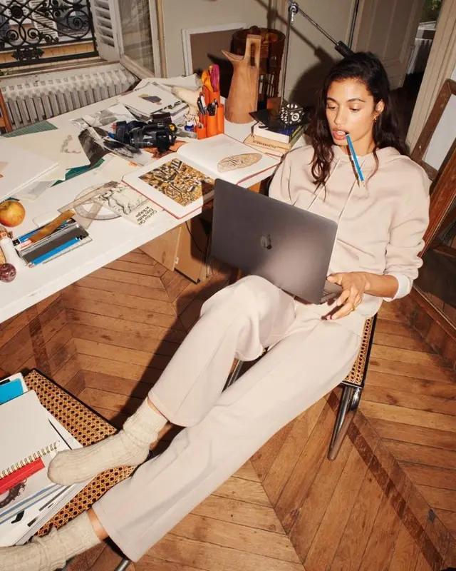 Beige loungewear and MacBook in a sunlit studio workspace
