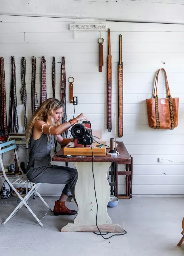 Artisan hand-stitching leather straps in New England studio