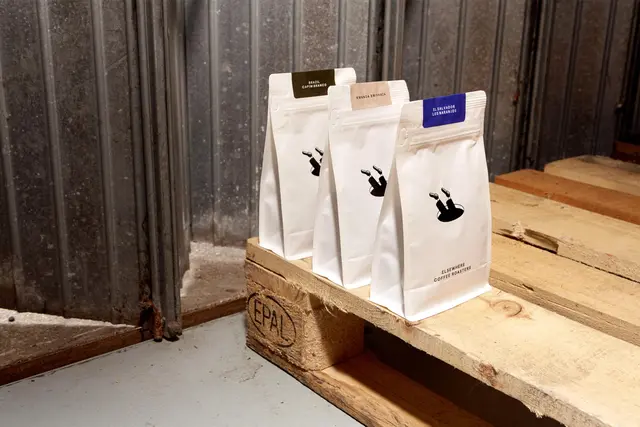 Elsewhere Coffee Roasters — minimal white pouches with diving-figure logo
