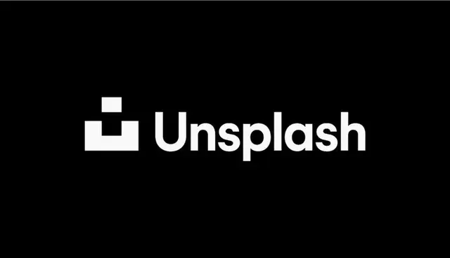 Unsplash rebrand — wordmark and square 'smile' logo on aerial beach photo