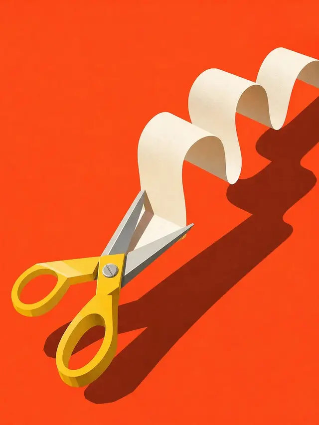 Yellow-handled scissors cutting a curled white paper strip on orange-red background