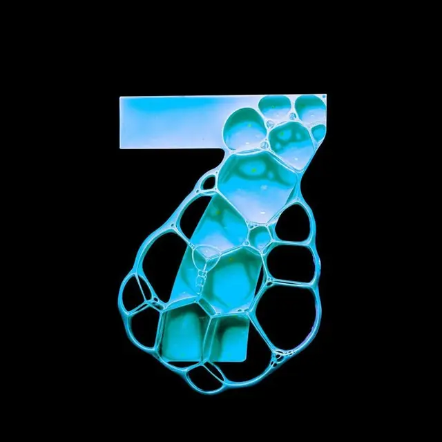 Soap-bubble numeral 7 — cyan macro photography