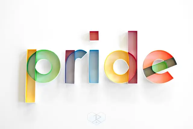 Translucent acrylic 3D typography spelling "pride" in rainbow colors