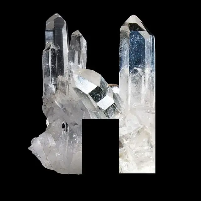 Clear quartz crystal cluster with rectangular negative cutout on black background