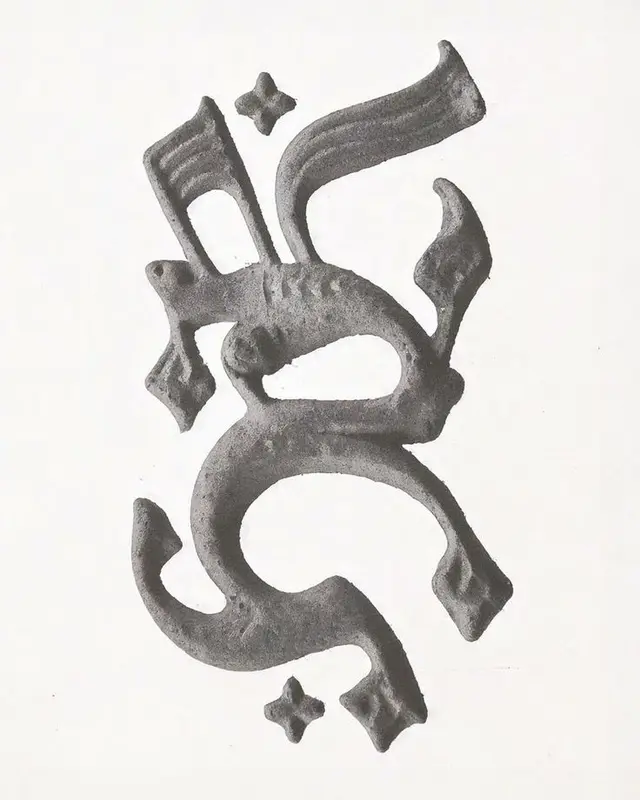 Ornamental calligraphic letterform relief, textured stone/metal