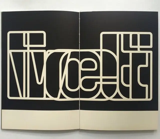 Cream outline geometric wordmark across two-page book spread