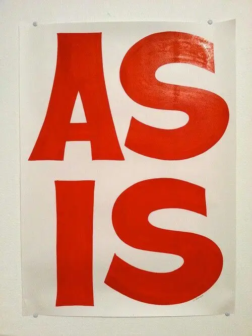 Red "AS IS" typographic poster pinned to wall