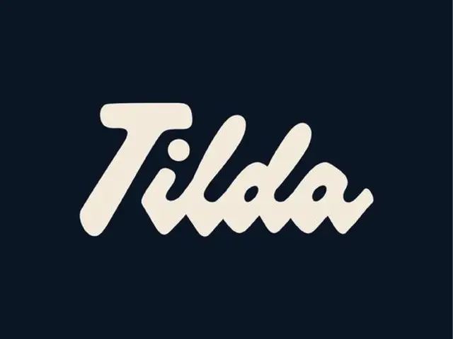 Tilda cream script wordmark on dark navy background