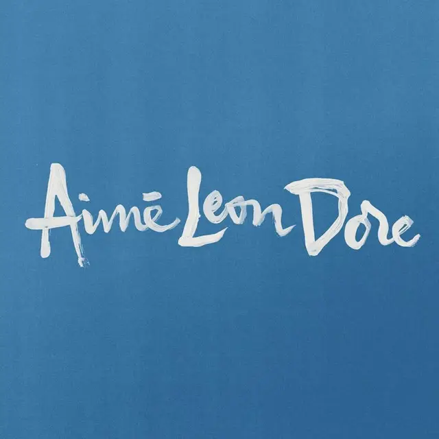 Aimé Leon Doré white brush-script logo on blue background