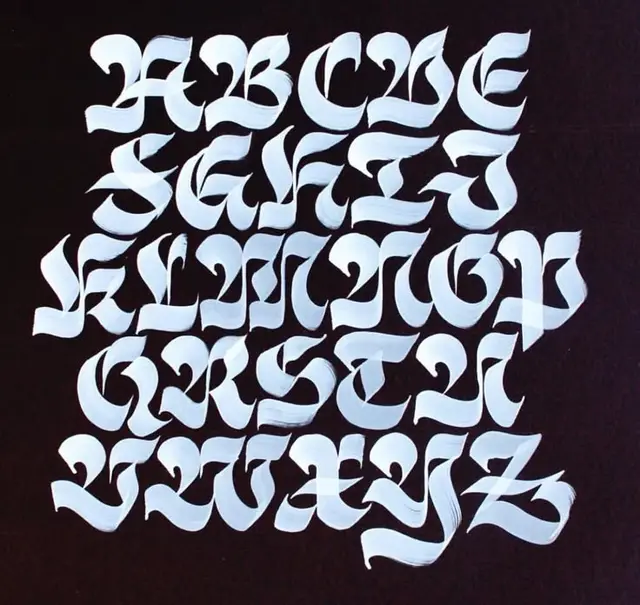 Hand-painted modern blackletter uppercase alphabet on black paper