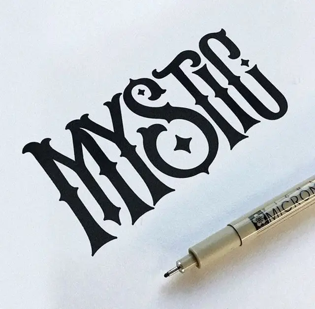 Ornamental blackletter hand-lettering on white paper with Micron pen