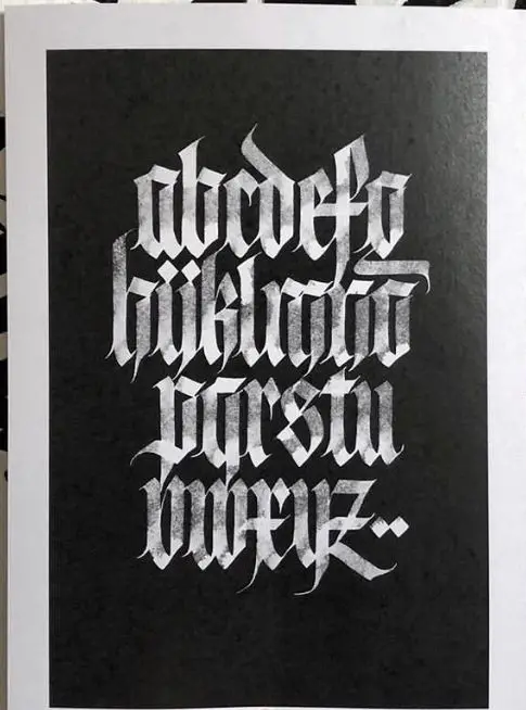 White blackletter alphabet on black textured paper