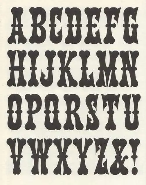 Ornamental condensed display alphabet on cream paper — vintage type specimen