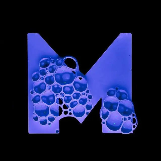 Neon blue letter M filled with soap-bubble texture